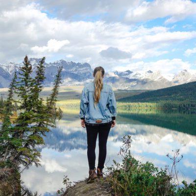 A woman looking out at the Canadian rocky mountains for the article: Canadian clothing brands from coast to coast